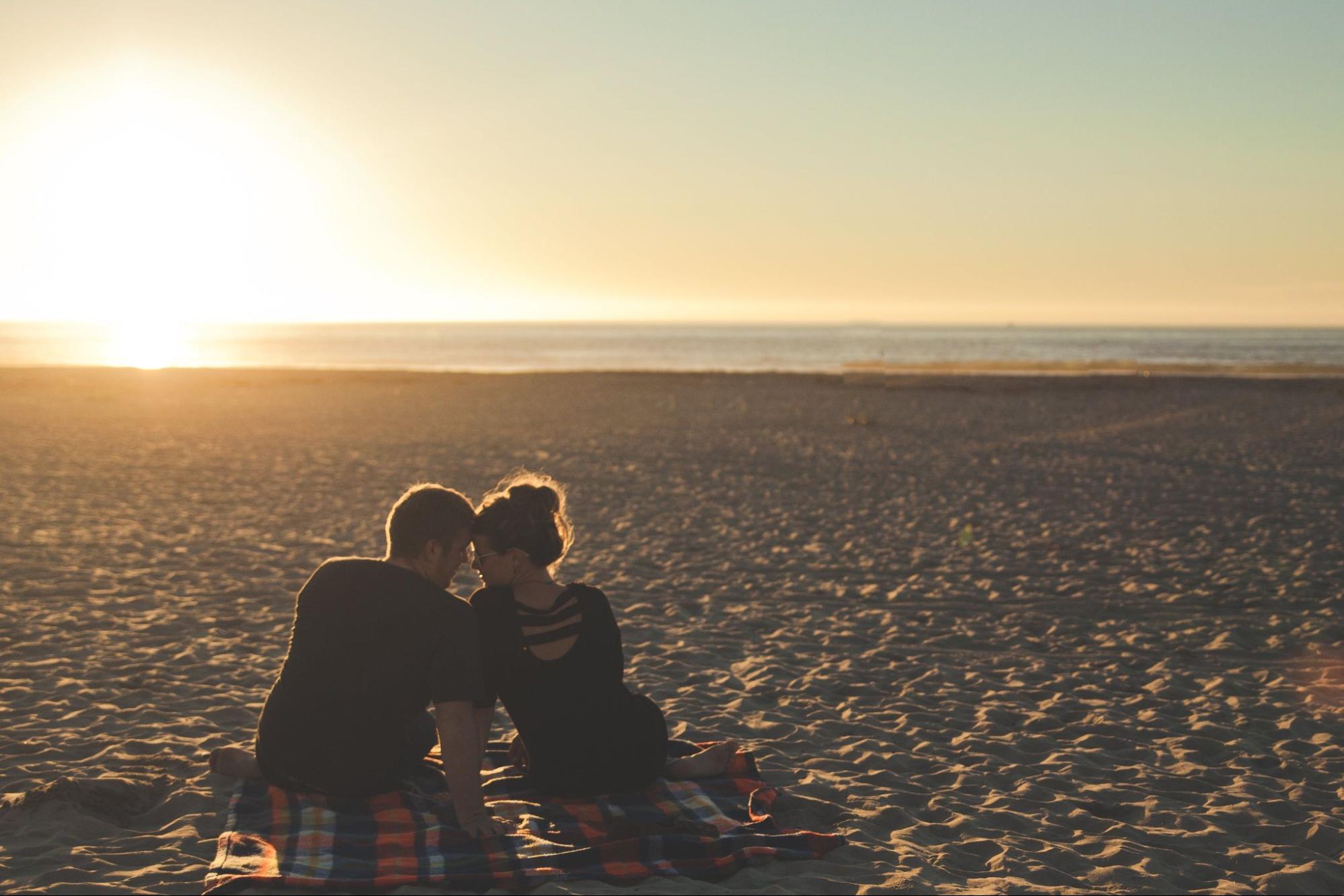 man-woman-sitting-on-beach-sunset.jpg