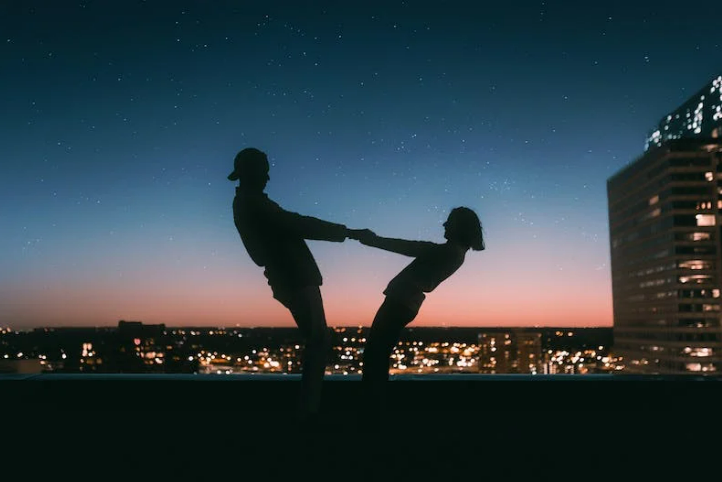 Silhouette-of-man-and-woman-on-rooftop-night-time